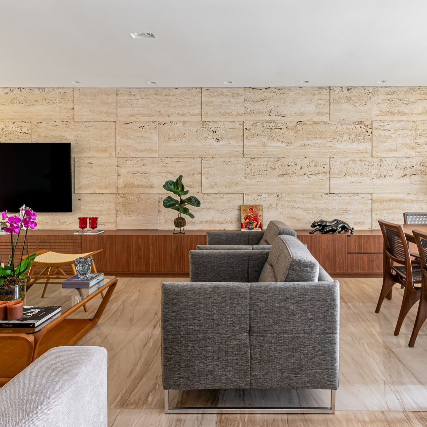 Sala de estar com parede de travertino e piso de mármore